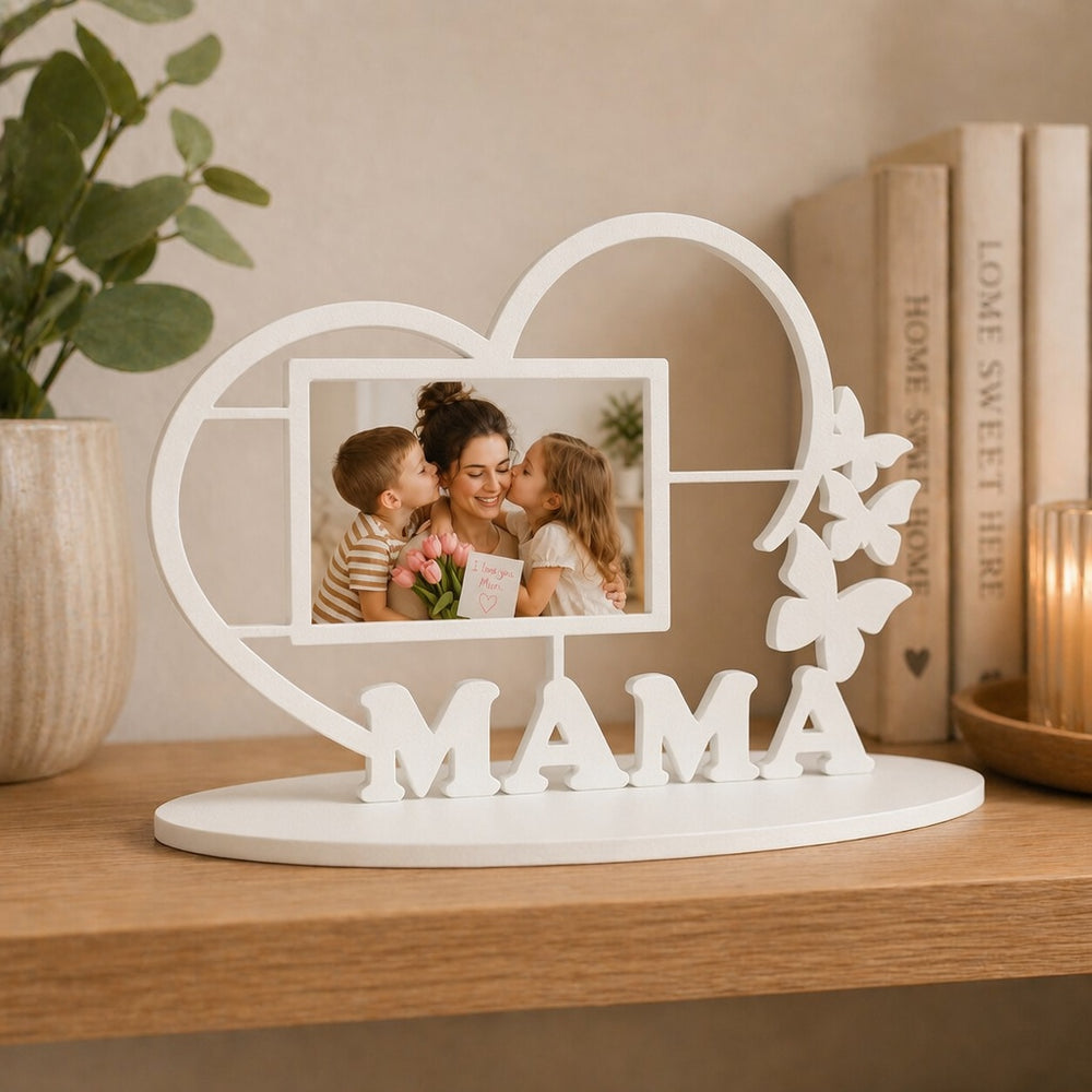 Decorative photo frame with 'MAMA' and a heart design on a wooden surface.