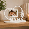 Decorative photo frame with 'MAMA' and a heart design on a wooden surface.