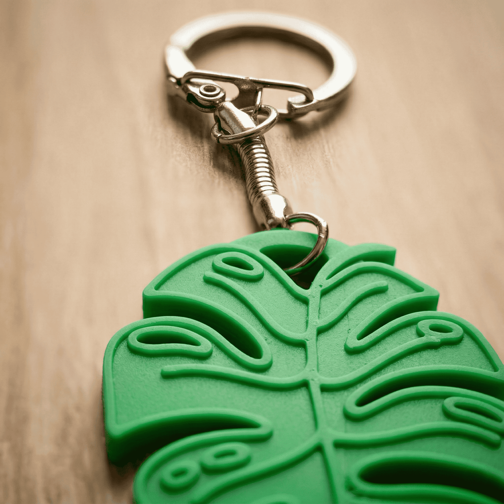 Green leaf-shaped keychain on a wooden surface