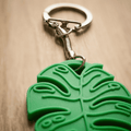 Green leaf-shaped keychain on a wooden surface