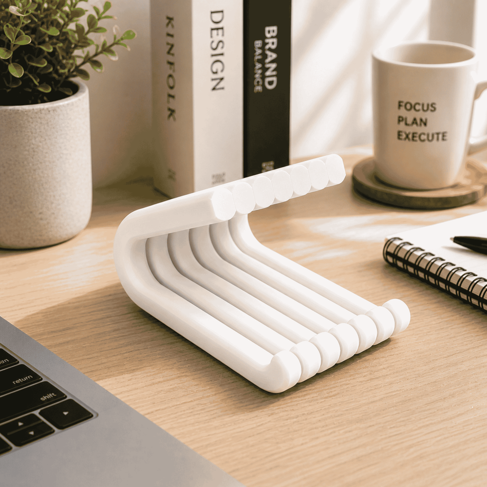 White desk organizer on a wooden desk with books, a mug, and a plant in the background.