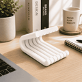 White desk organizer on a wooden desk with books, a mug, and a plant in the background.