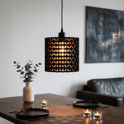 Modern pendant light hanging above a dining table with candles and a vase.