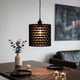 Modern pendant light hanging above a dining table with candles and a vase.
