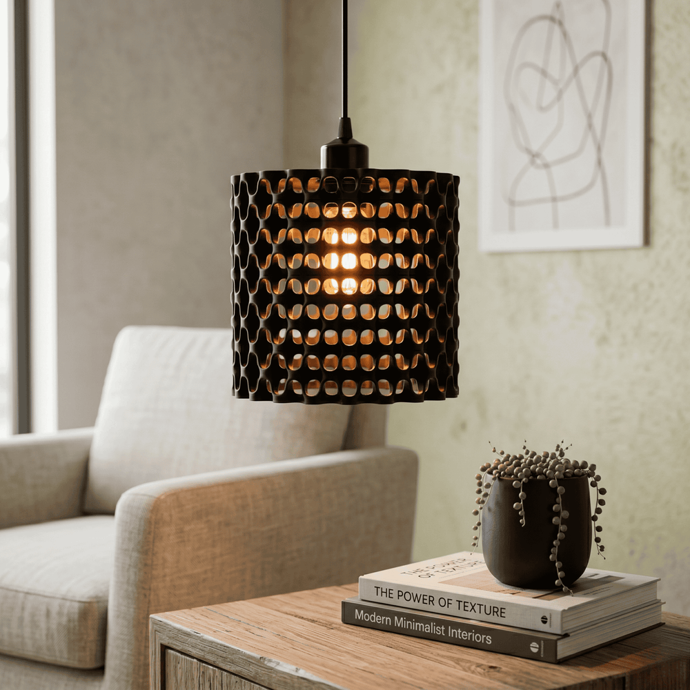 Modern pendant light hanging above a table with books and a plant in a living room setting.