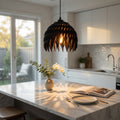 Modern kitchen with a pendant light, marble island, and decorative elements.