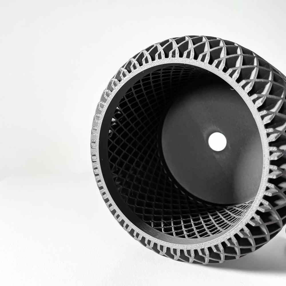 Close-up of a black and silver tire with unique tread pattern on a white background