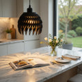 Modern kitchen with marble island, open cookbook, and decorative flowers.