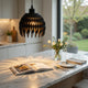 Modern kitchen with marble island, open cookbook, and decorative flowers.