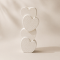 Decorative sculpture of three stacked heart shapes on a beige background